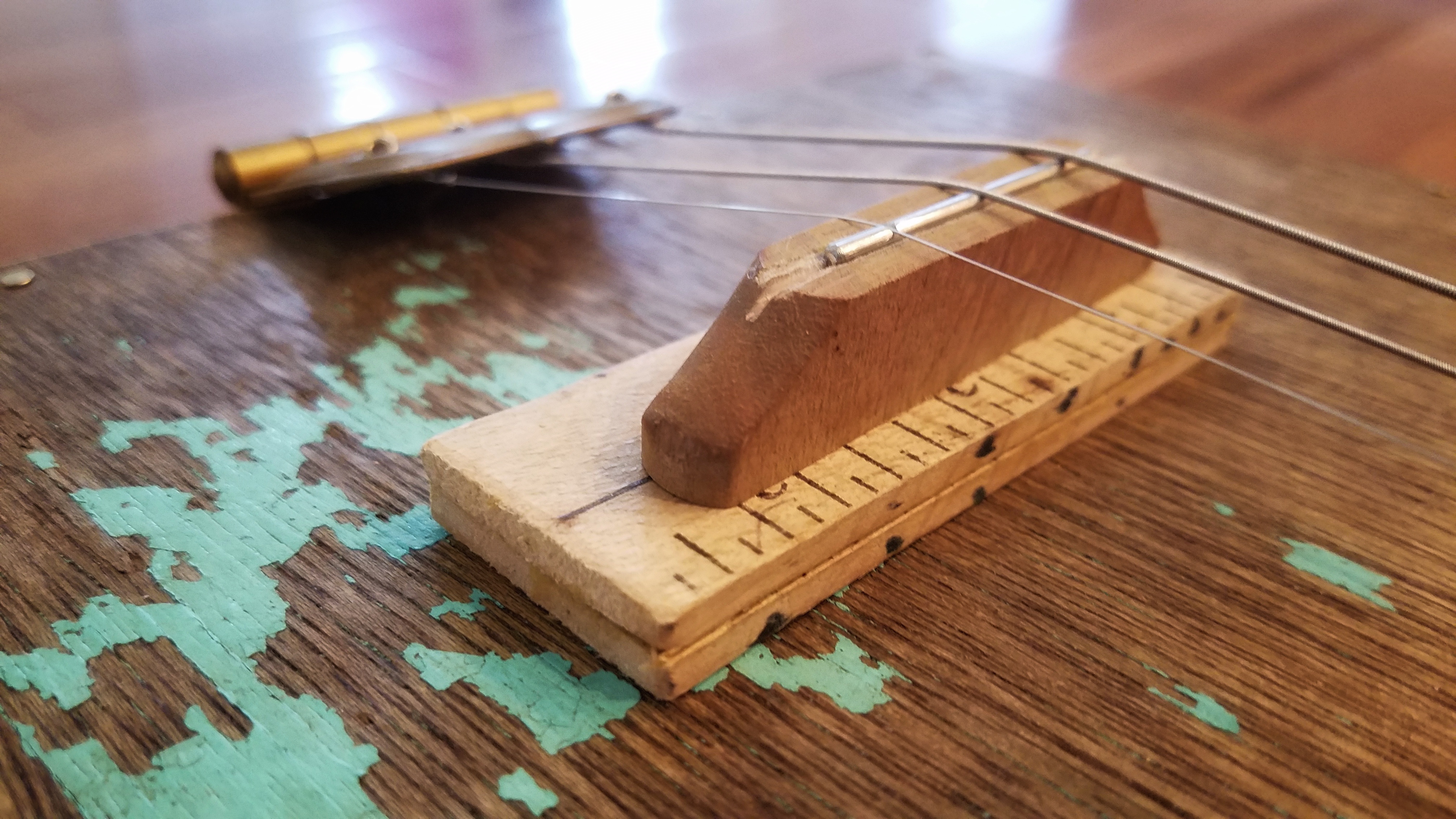 An old ruler holds the bridge, which is a part of a paint brush