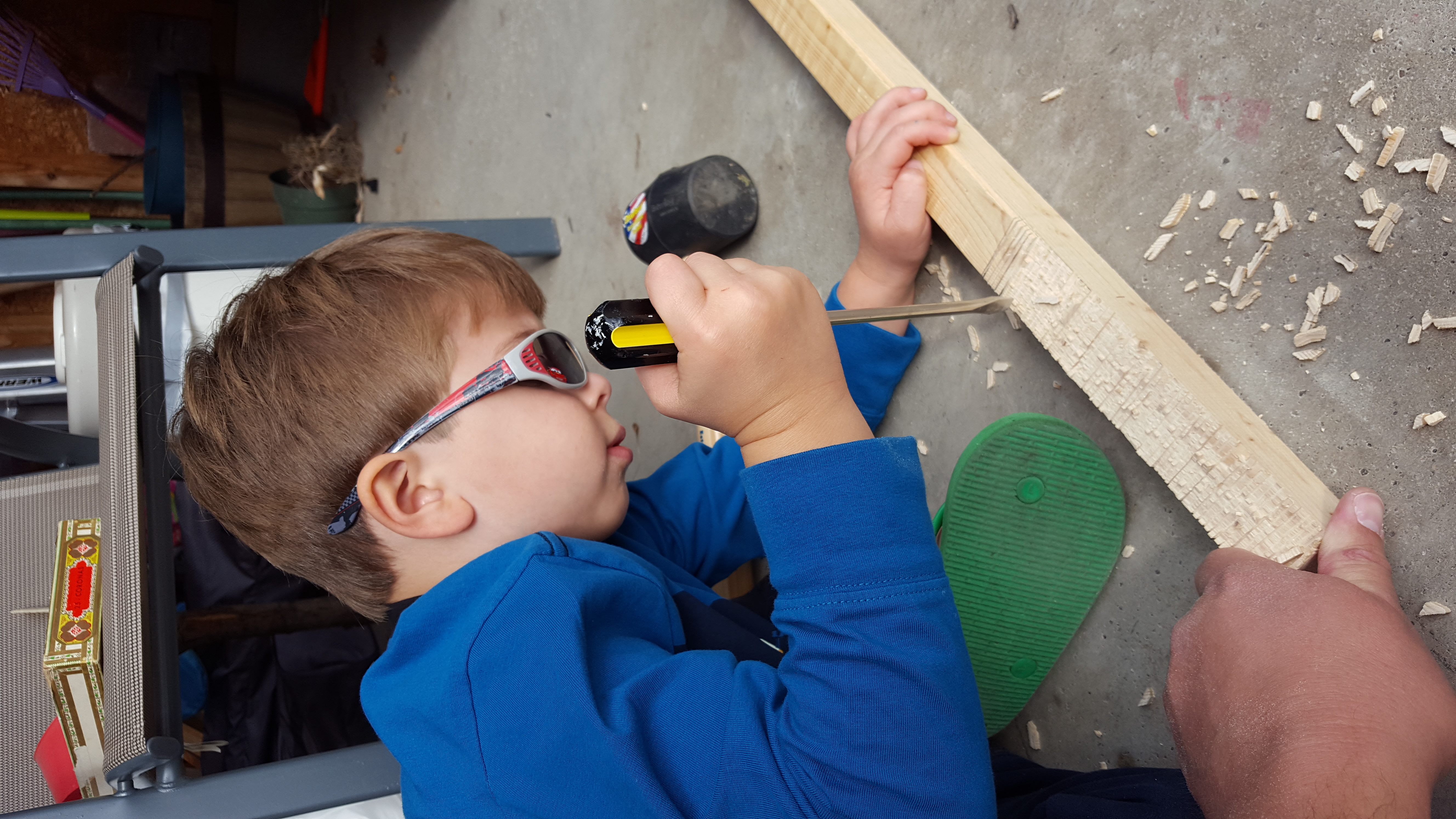 Making space for the lid to close over the neck. You make a bunch of shallow cuts, then use a screwdriver to snap them off. Then sand down to smooth