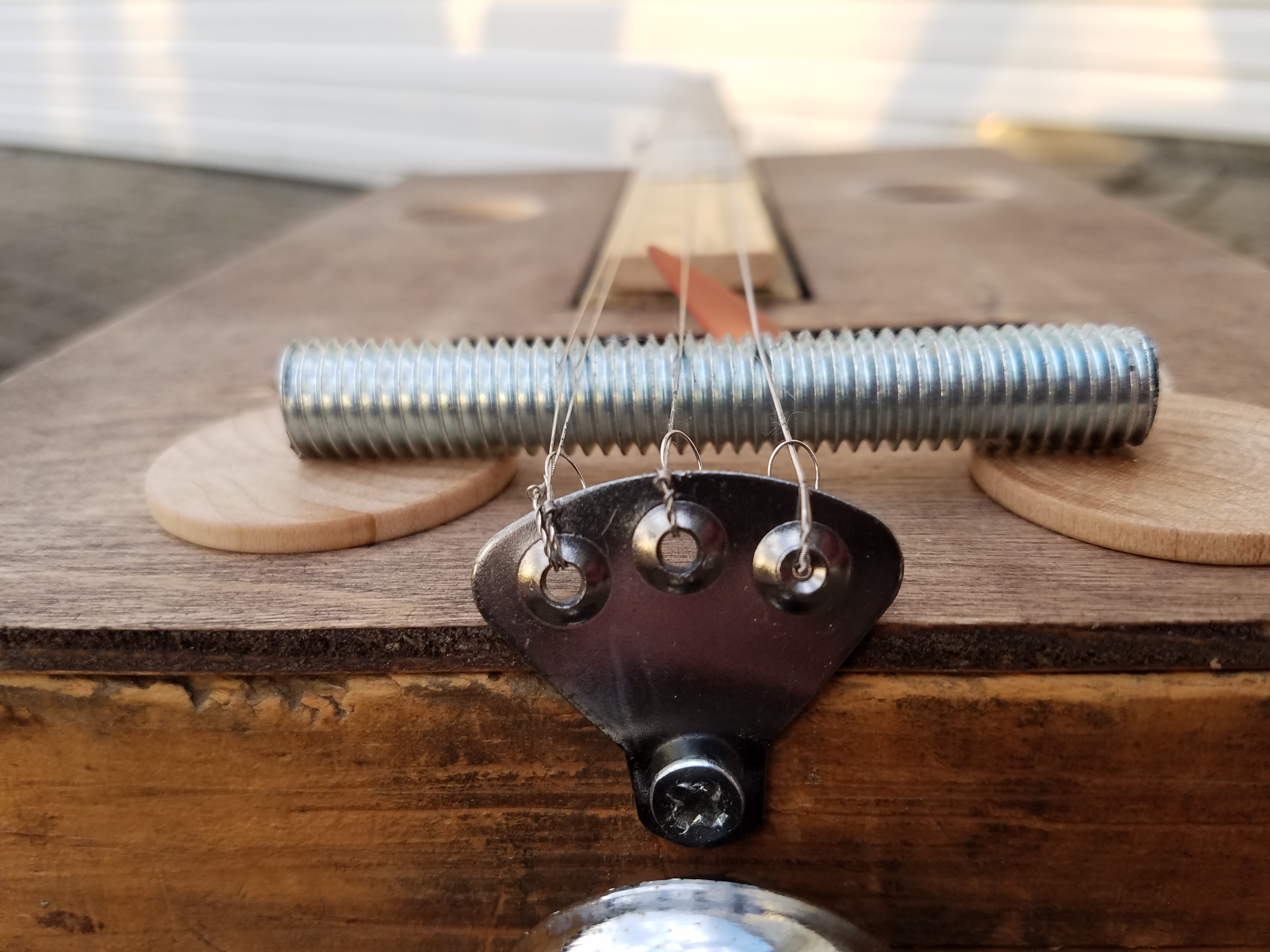 A three nail picture hanger to hold the strings