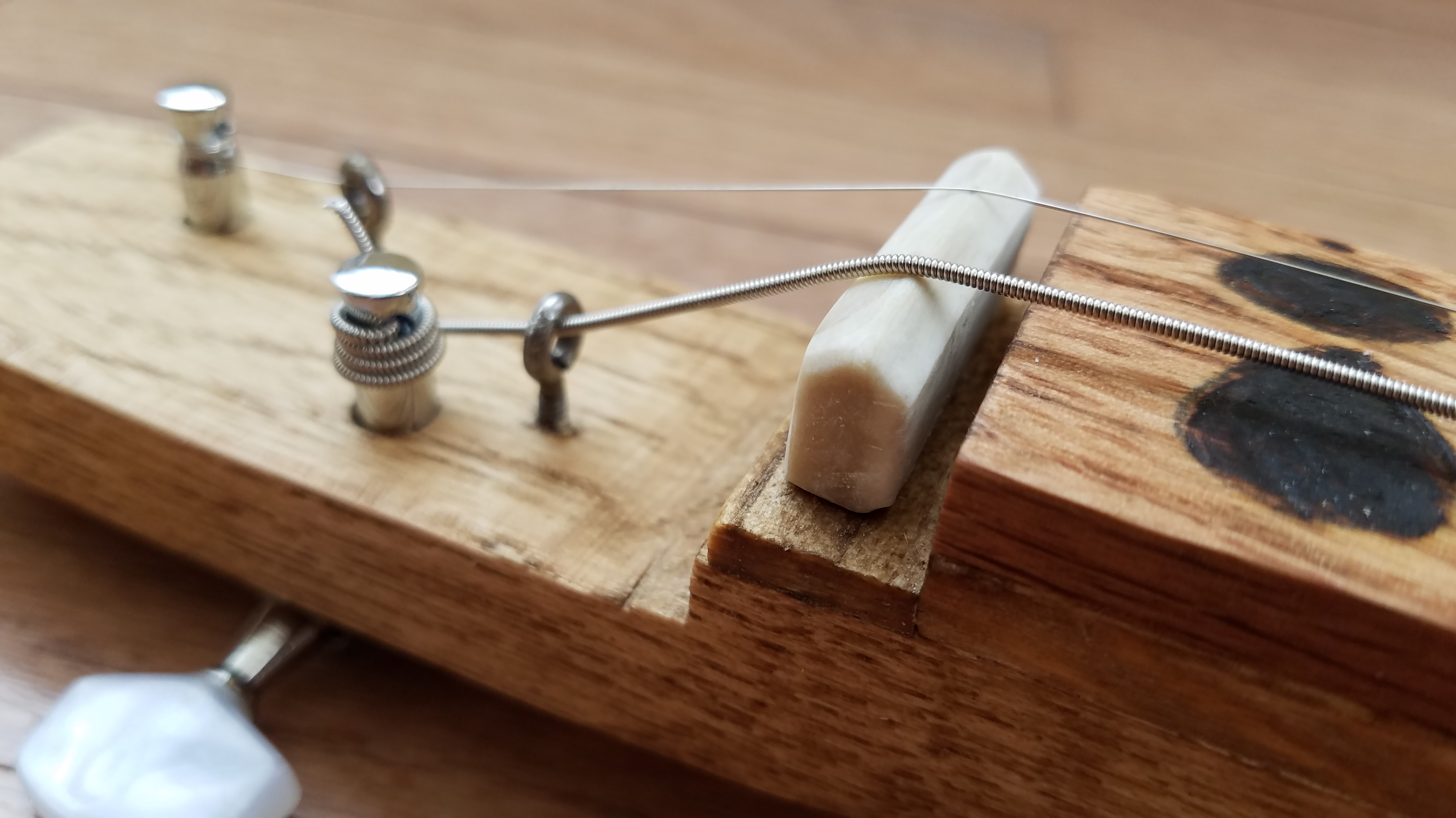 Hand carved bone nut, held down by string tension