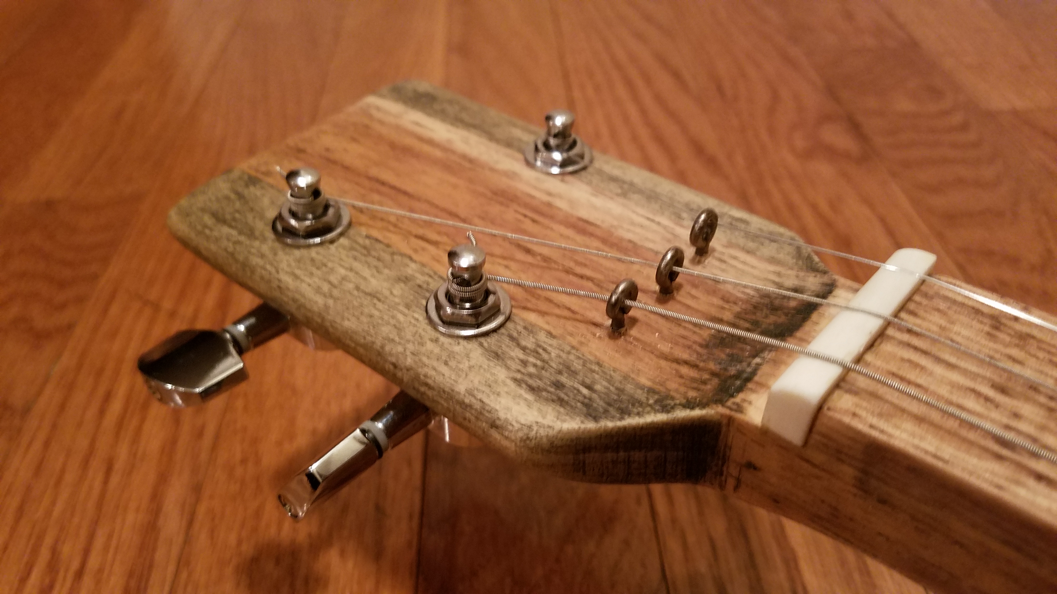 The string loops are from a piano from the 1890&rsquo;s that was dumped on the side of the road. Notice how the stain colored the two different types of wood in the headstock differently