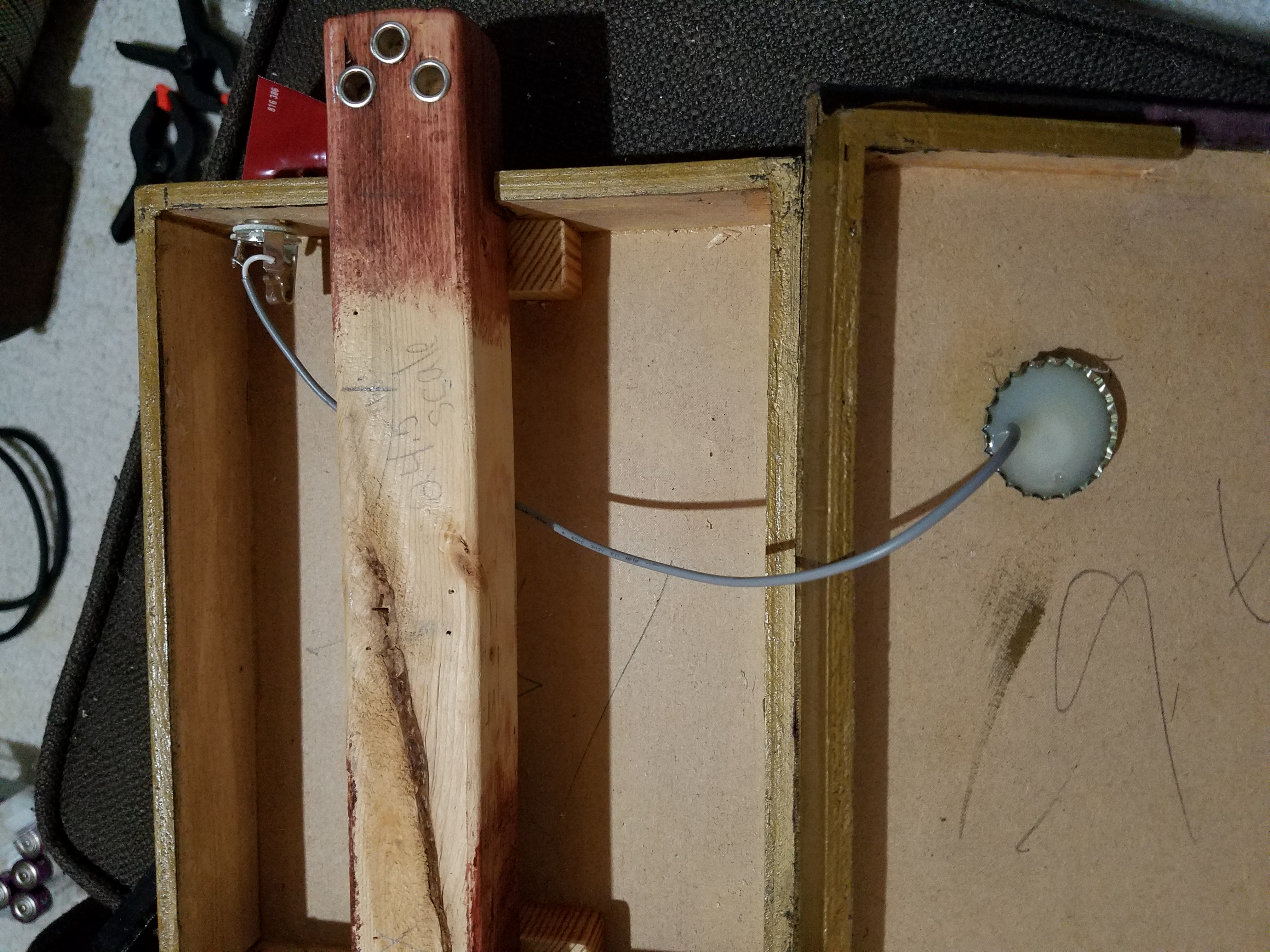 Piezo (contact mic) inside a bootlecap, glued to the inside of the case so we can play this gitty through an amp