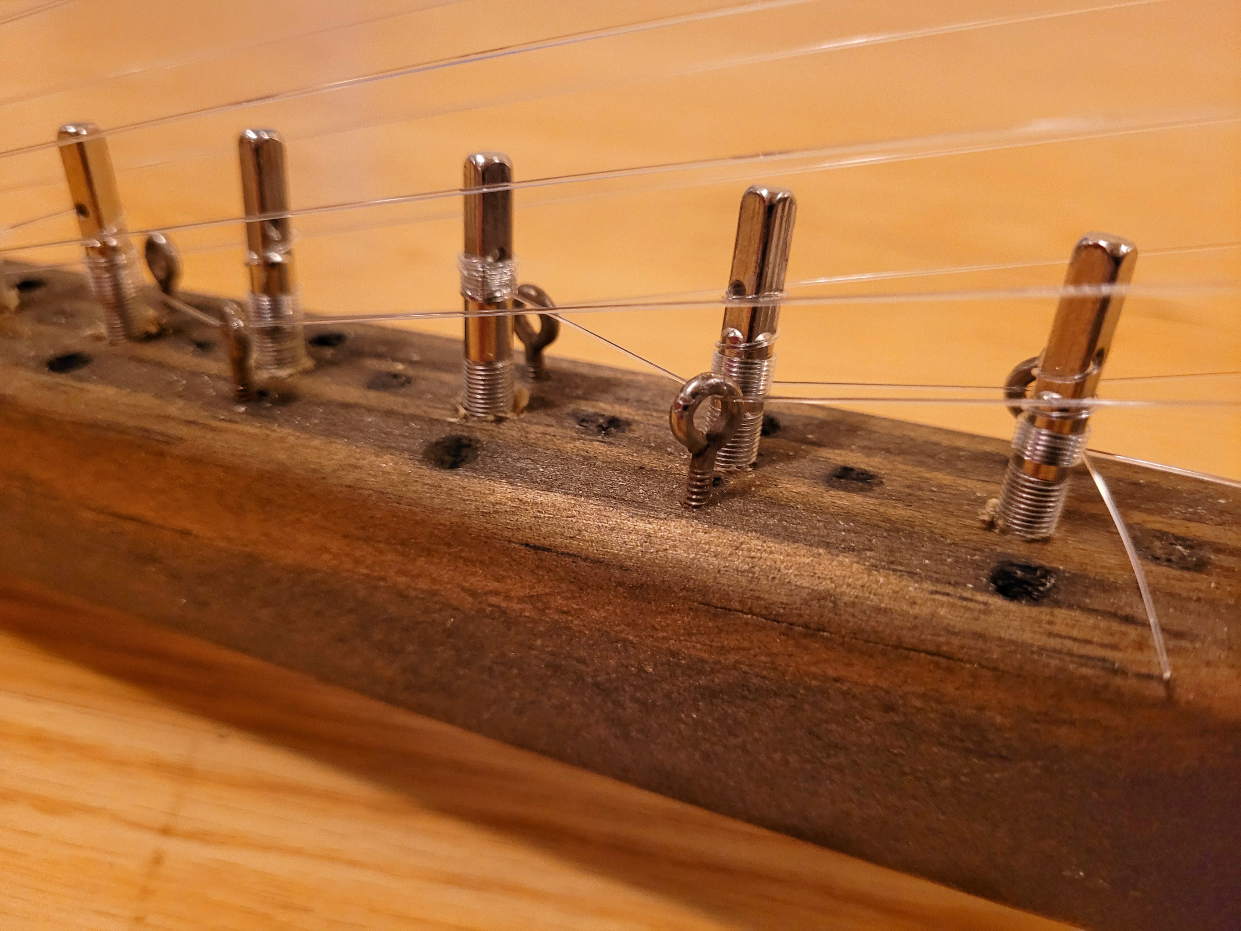 Eye hooks were salvaged from a 1890’s piano. The extra holes on the neck are there 100% for decoration and not at all because I drilled all the holes, then decided I needed the zither pins arranged differently